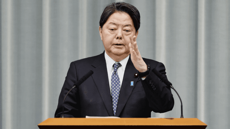 Alt Text: *A person using a smartphone with a cybersecurity alert on the screen, symbolizing Japan’s effort to strengthen online security laws.*