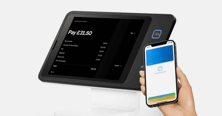 Alt Text: "A business owner using Square technology on a tablet to analyze economic trends and AI-driven insights for retail strategy."