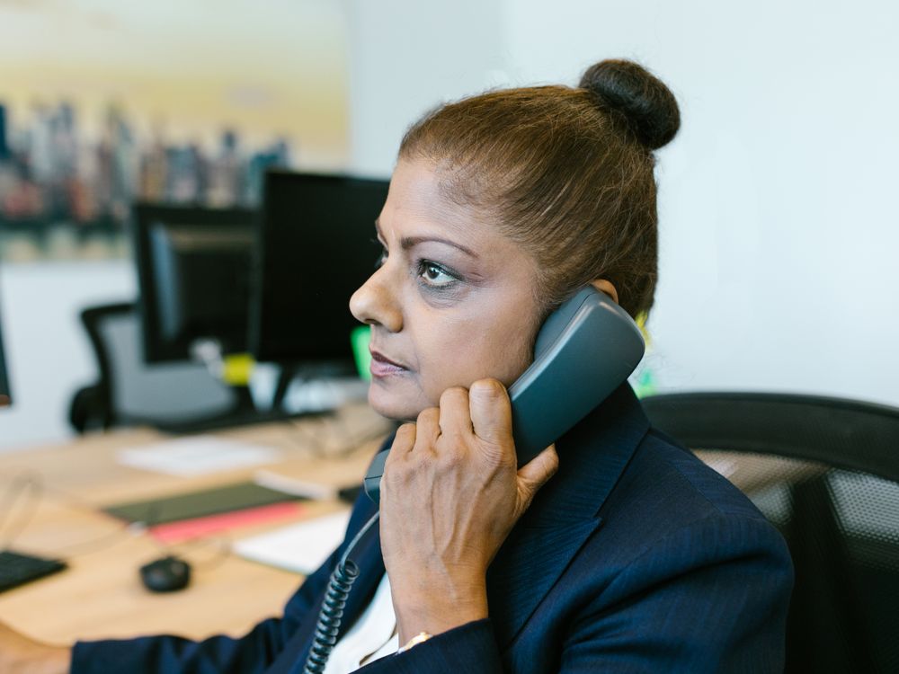 Professional businesswoman taking a call at her office desk