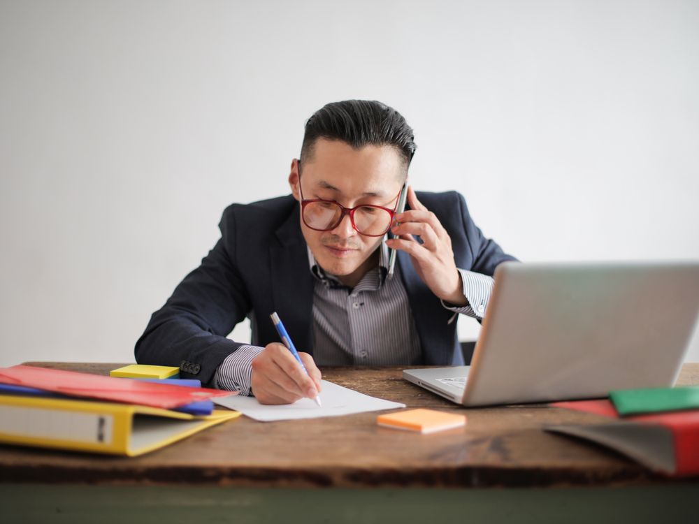 Business owner taking a call at their laptop — calls reach you on your phone or your computer